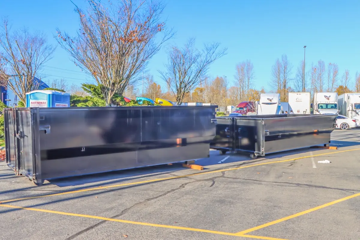 Professional dumpster rental service with roll-off container on residential driveway in El Campo